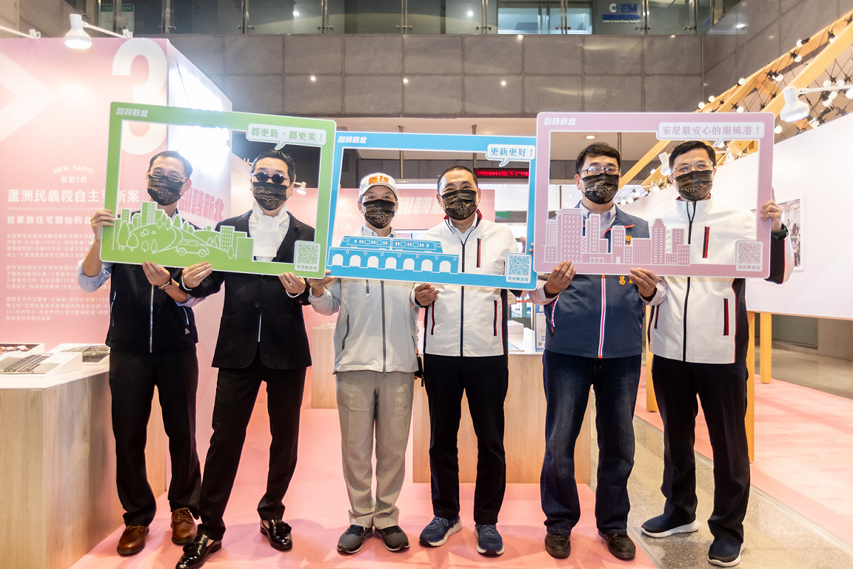 侯友宜與貴賓拿著都更三箭框景合影。 圖：新北市都更處提供