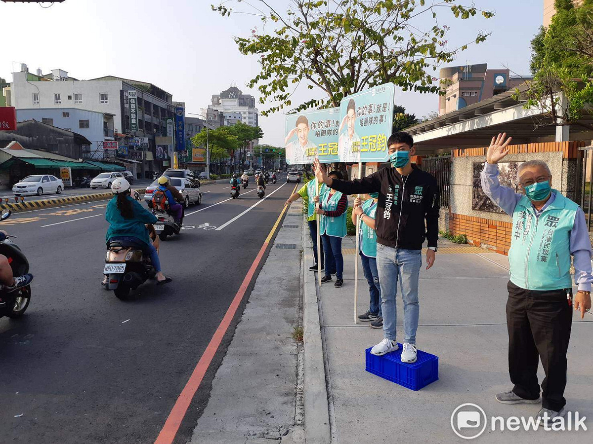 台灣民眾黨嘉義市西區市議員擬參選人王冠鈞，今（6）日站在路口拜票。 圖：蔡坤龍/攝