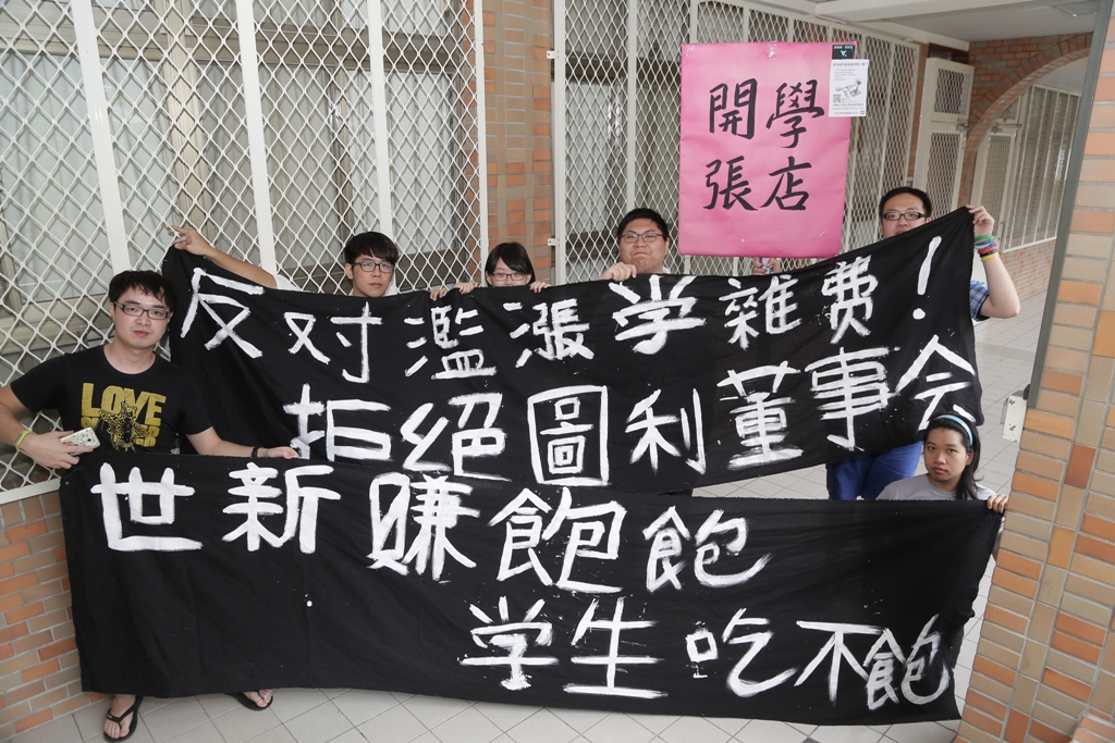 世新大學勞權小組於11日下午在學雜費調整公開說明會現場，高舉布條抗議。 圖：世新大學勞權小組提供