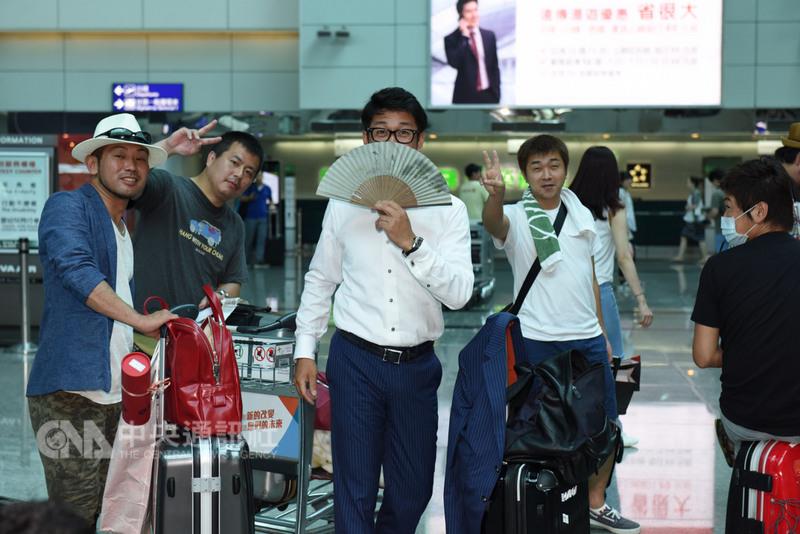 桃園機場二航廈因淹水停電，3天沒空調，5日清晨原本一度恢復運作，卻又因跳電停擺，有民眾自備扇子搧風降溫。 圖：中央社