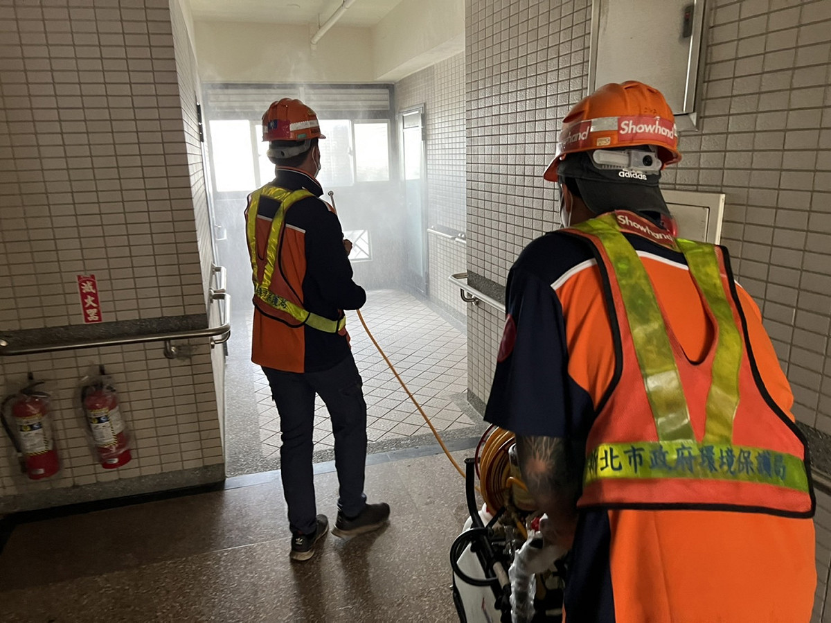 新北市環保局公布接獲案例通報後，多次安排前往該社區消毒；圖為 4月15日由里長陪同前往社區內走廊及梯間消毒照。 圖：新北市環保局/提供