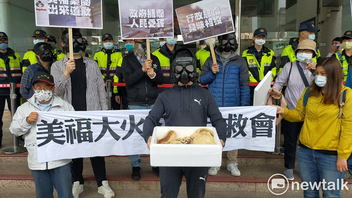 美福自救會成員戴著防毒面具準備一盒腐肉，要求環保局長呂理德也聞一下南崁民眾一個多月來每天聞的臭味。