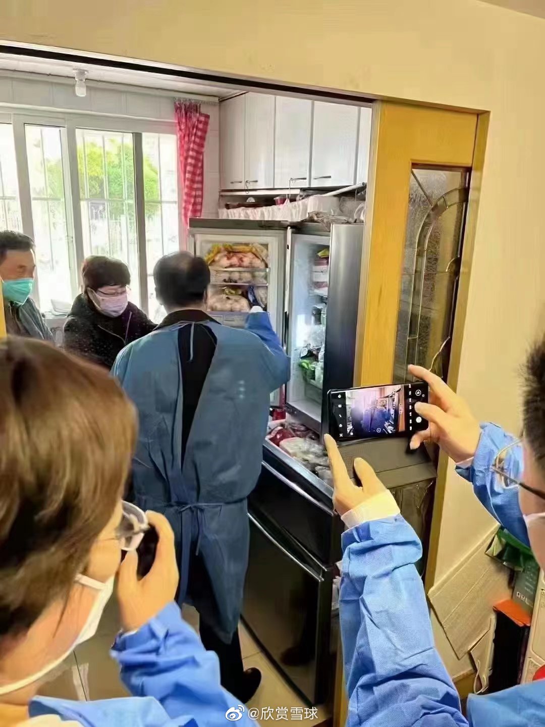 上海市副市長陳通19日前往社區視察物資供應，因為雙手一直藏在袖子裡而挨批，而一戶民宅的桌上及冰箱堆滿大量食物。 圖：翻攝自微博