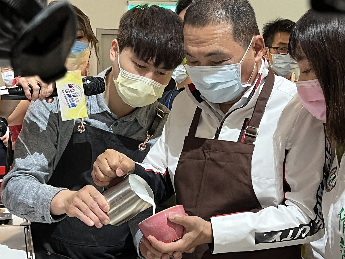 侯友宜在拉花冠軍林紹興的現場教學後，準備PK餐飲業青年。 圖：新北市職訓中心提供