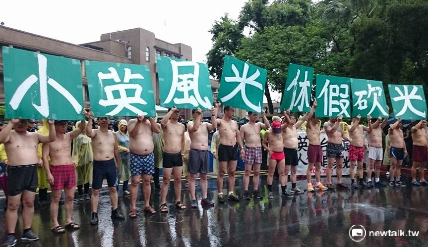 工鬥連線14日上午在行政院前裸身抗議，工人裸上半身手持「小英風光，休假砍光」字牌，抗議總統蔡英文和勞動部上台後大砍勞工7天假。 圖：新頭殼資料照片