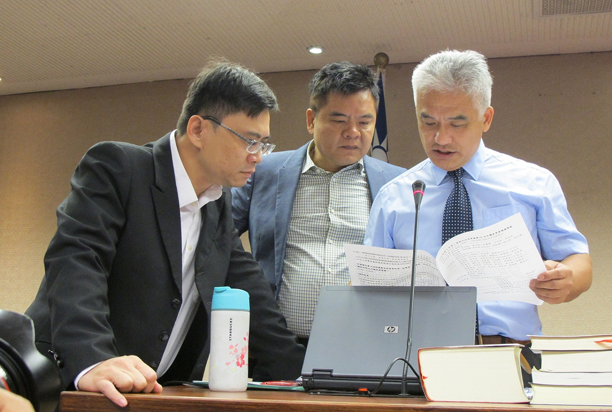 立法院內政委員會議事人員15日宣讀上次會議記錄時，民進黨立委莊瑞雄、賴瑞隆兩人站在一旁監督。 圖：林朝億/攝