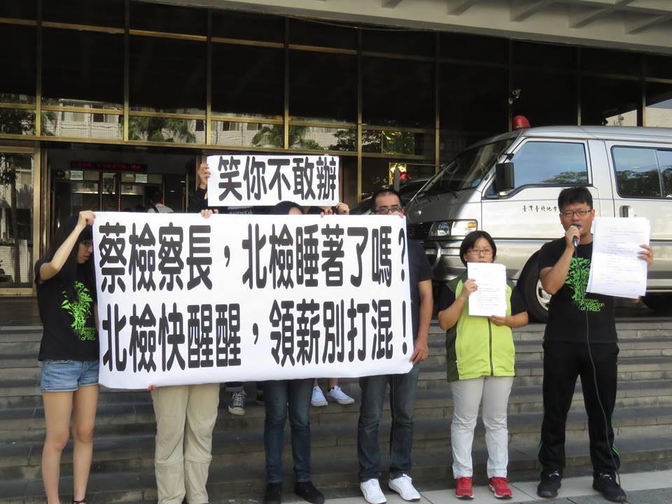環保團體在地檢署前手持標語，呼籲檢調盡速約談涉入大巨蛋弊案的相關人士。 圖：松菸護樹志工團提供