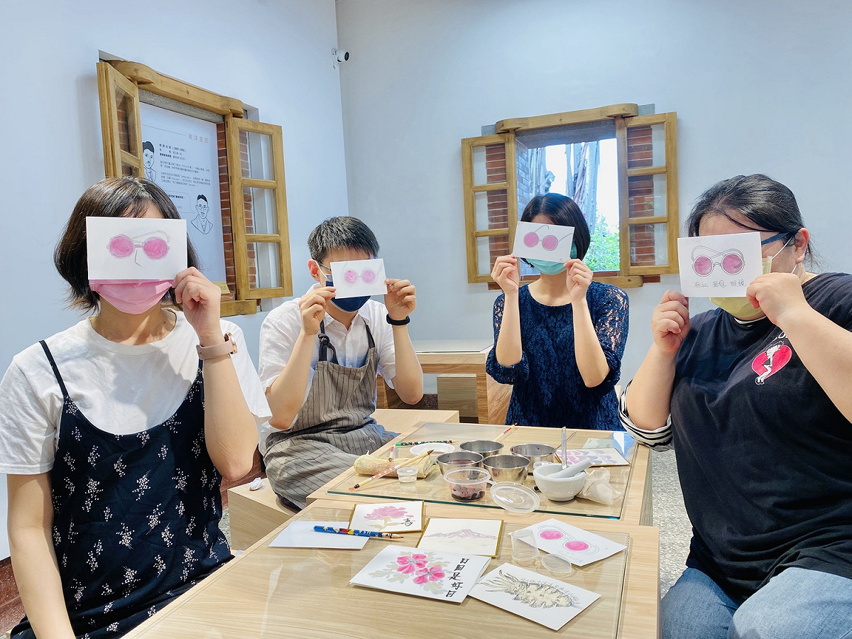 淡古駐村藝術家佘心婷（右1）利用桑葚與調膠融合出粉紅色，DIY畫出木下常配戴的墨鏡款式。 圖：淡水古蹟博物館提供