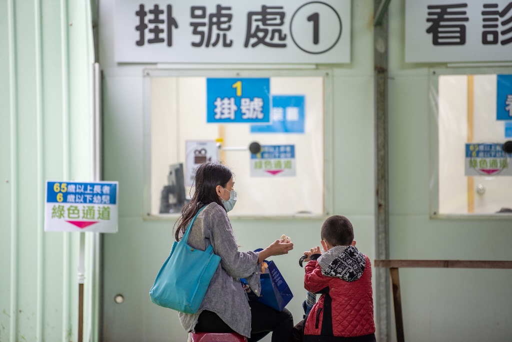 桃園市９處社區採檢站今起全面啟用長幼三合一綠色通道，開放6歲以下、65歲以上優先採檢PCR、看診、領藥一次到位，一位母親帶著小孩前往看診拿藥。 圖：桃園市衛生局／提供