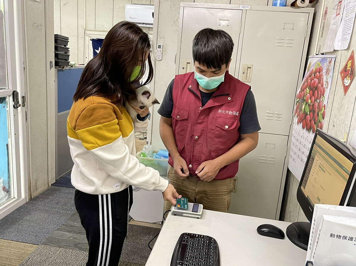 民眾帶著愛貓注射狂犬病疫苗，使用悠遊卡支付規費。 圖：新北市動保處提供