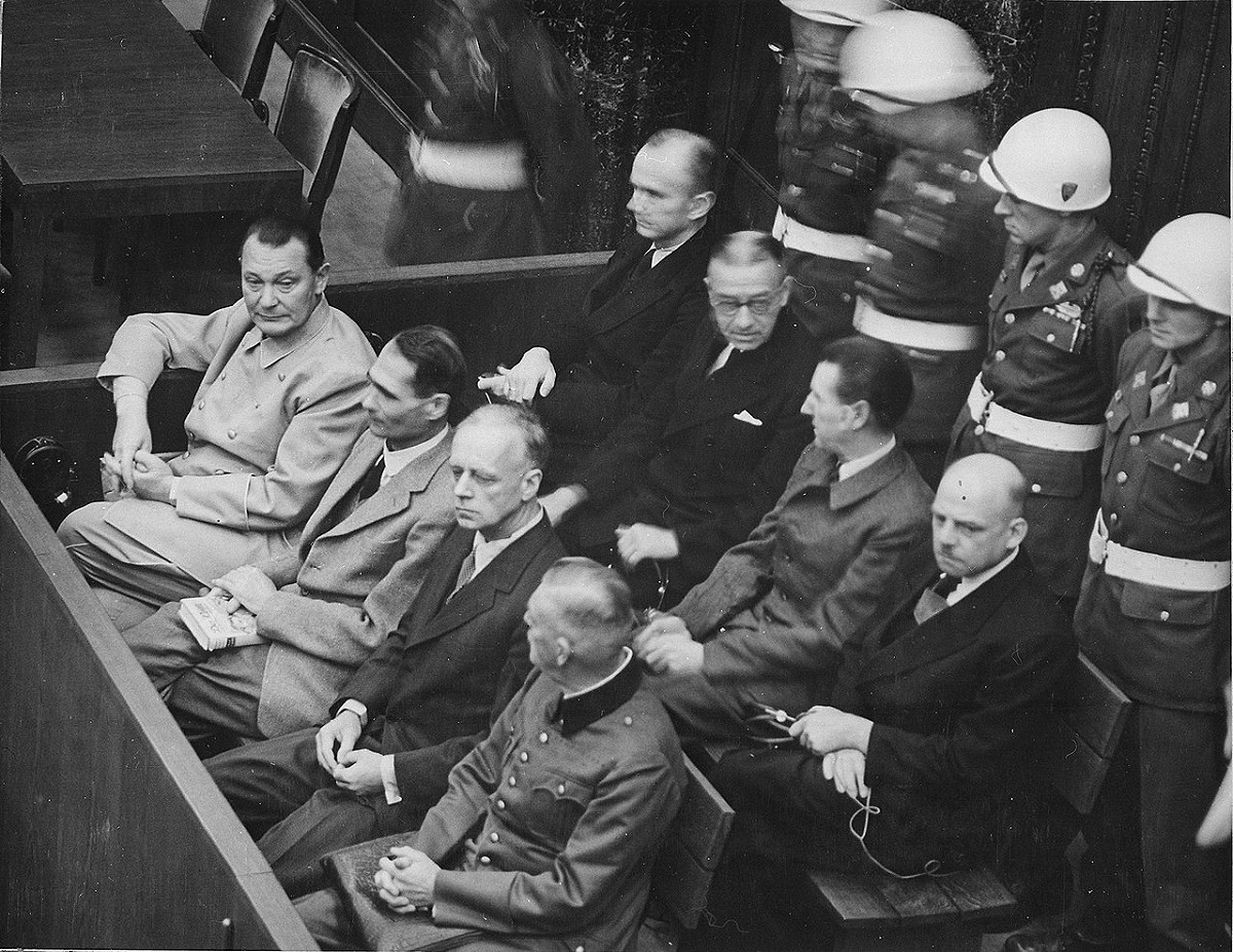 紐倫堡審判中由左至右依序為戈林（Hermann Göring）、赫斯（Rudolf Heß）、里賓特洛甫（Ulrich von Ribbentrop）、凱特爾（Wilhelm Keitel）；後排：鄧尼茨（Karl Dönitz）、雷德爾（Erich Raeder）、席拉赫（Baldur von Schirach）、紹克爾（"Fritz" Sauckel），他們均為納粹德國的軍政首領。 圖：翻攝自維基百科
