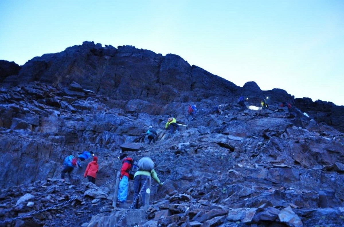 學員在歷經曲折碎石山徑攀登到玉山主峰，俯視大自然鬼斧神工的美。