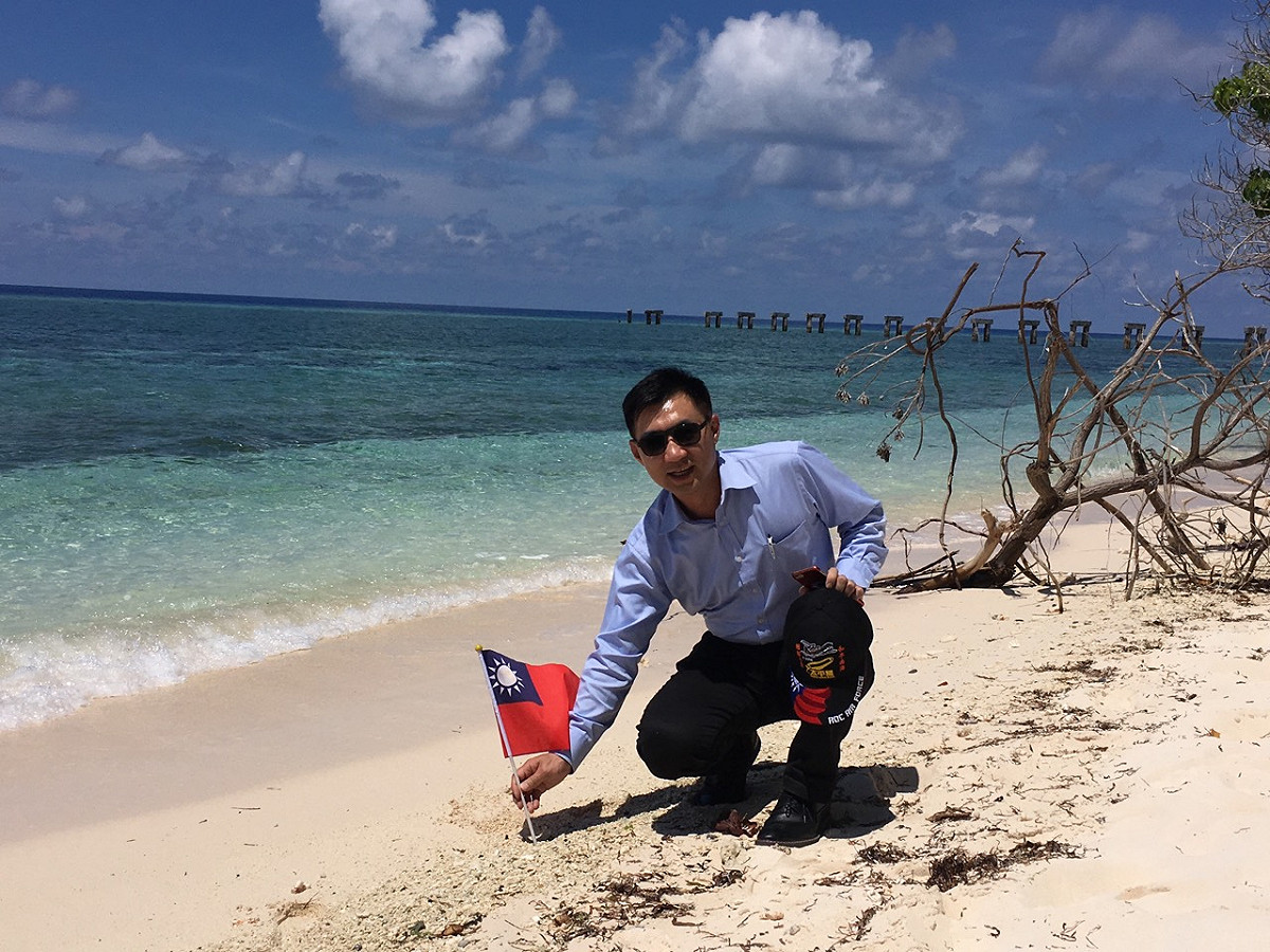 國民黨立委江啟臣登島後，在太平島上插上中華民國國旗。 圖：江啟臣辦公室/提供（資料照）