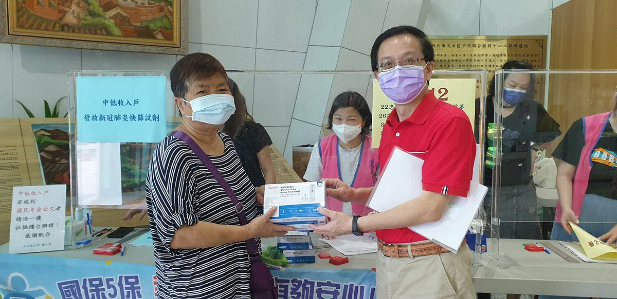 淡水區長巫宗仁（右）親自發送快篩劑給弱勢戶。 圖：新北市社會局提供