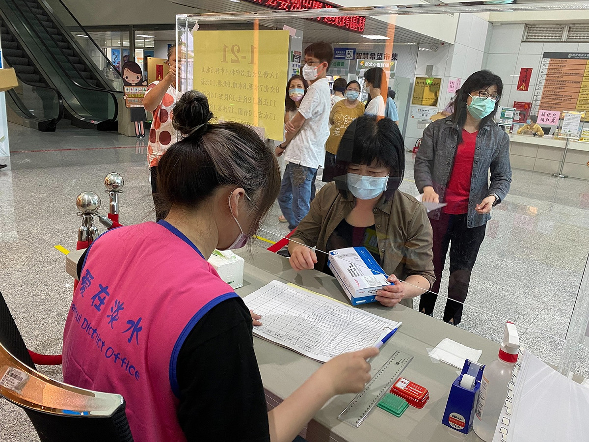 淡水區公所社文課正在發放快篩劑。 圖：新北市社會局提供