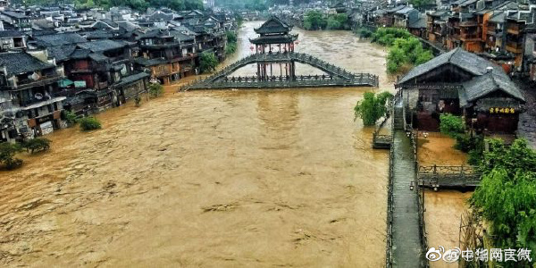 受暴雨影響，湖南鳳凰縣沱江水位上漲，橫跨沱江的古橋遭水淹沒。 圖：翻攝自微博