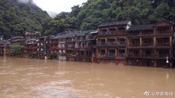 受暴雨影響，湖南鳳凰縣沱江水位上漲，橫跨沱江的古橋遭水淹沒，兩岸的建築也都被淹。 圖：翻攝自微博