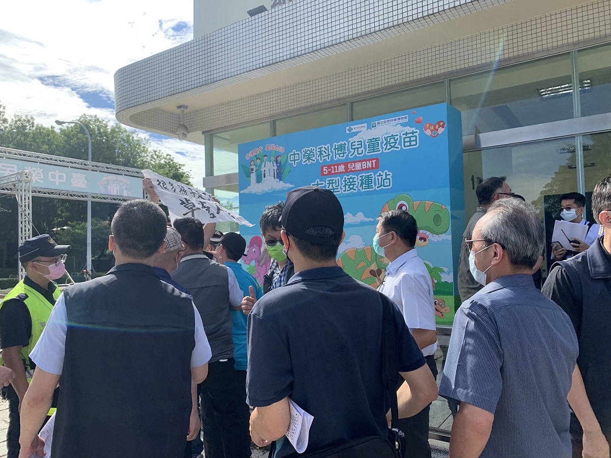 國民黨台中市黨部發言人鄭伯其高舉「很多孩子走了」、「冷血酷吏草菅人命」欲向蘇貞昌陳情，立即遭隨扈架走。 圖：鄭伯其/提供