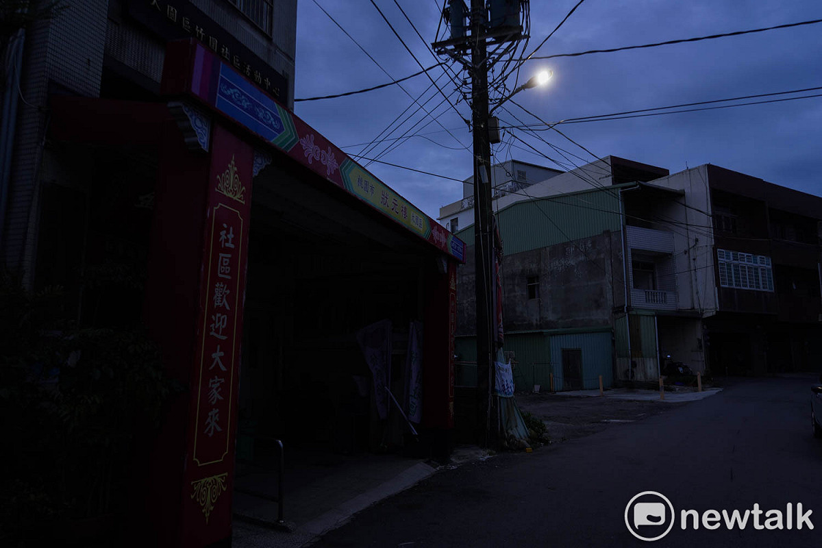 桃園市大園區竹圍社區發展協會的外牆架設的牌樓，上面寫著：社區歡迎大家來。不過，此刻的實際情況是巷子內的住戶大部份已經遷移他處，只剩一盞路燈照著無人跡的巷弄。 圖：張良一/攝