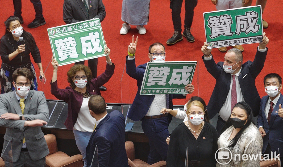 到立法院訪問的斯洛伐克官員和國會議員參觀立法院議場時，好奇的高舉在朝野表決大戰中的「贊成」手舉牌。 圖：張良一/攝