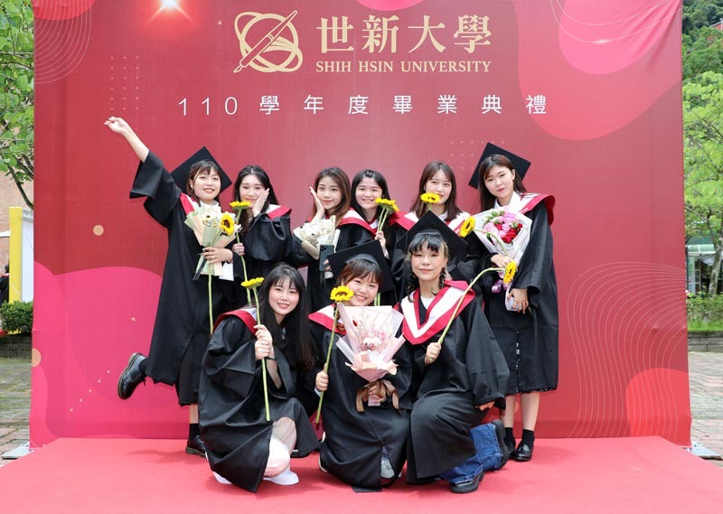 世新大學畢業典禮戶外拍照區，各班代表慶祝畢業。 圖：世新大學提供