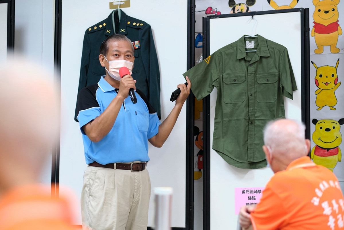 五股貿商社區發展協會理事長高甯松為社區長者介紹自身軍旅生活及豐富的軍人用品。