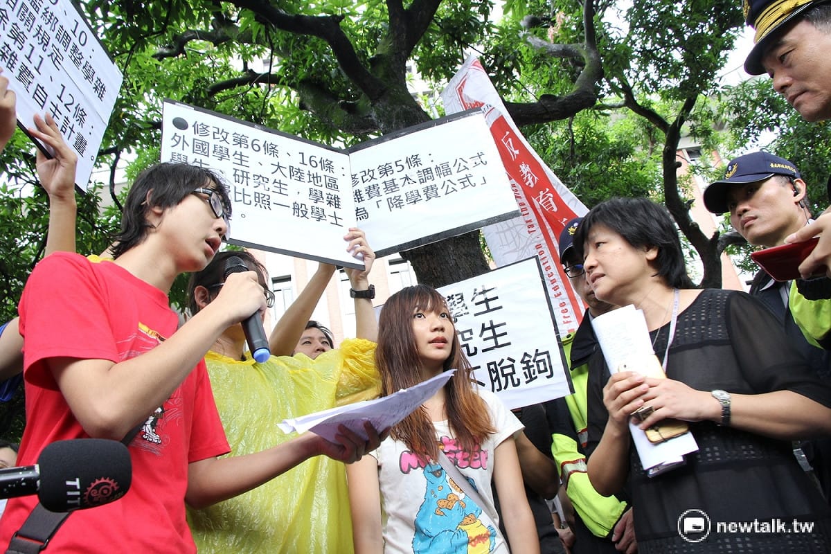 反教育商品化聯盟11日至教育部前陳情，要求修正《專科以上學校學雜費收取辦法》，教育部教教司科長李惠敏（右）出面回應並接下反教盟提出的修法草案。 圖：趙廣絜/攝