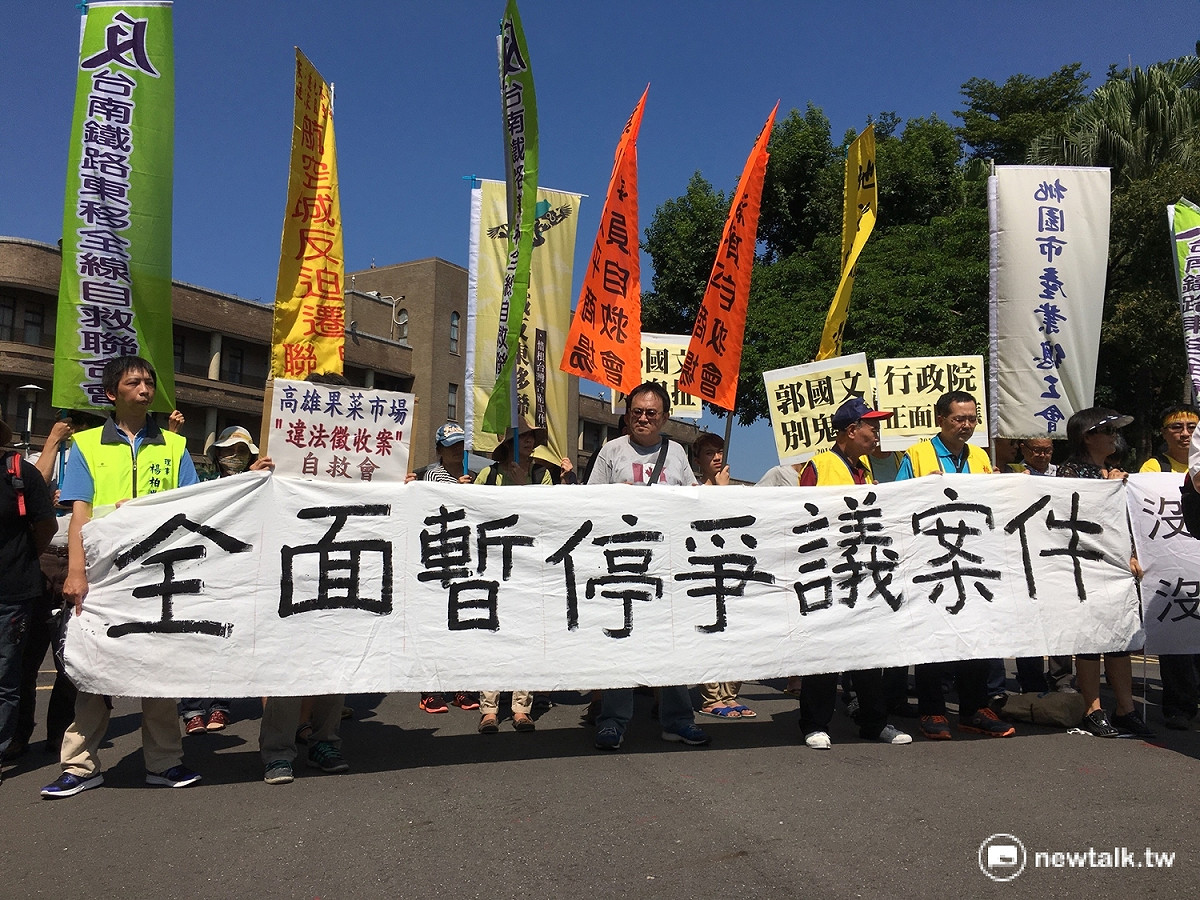 南鐵東移自救會成員22日下午在行政院門前舉辦記者會，要求全面暫停爭議案件並舉辦聽證會，落實土地正義。 圖：邱筠文/攝