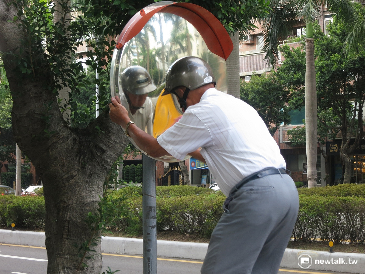 張秀雄現場示範每天如何擦拭反光鏡，只見他手腳俐落爬上梯子，不到三兩下原本髒污的鏡面就已變得乾淨
，根本看不出已是年過7旬的老翁。 圖：呂佳峻/攝