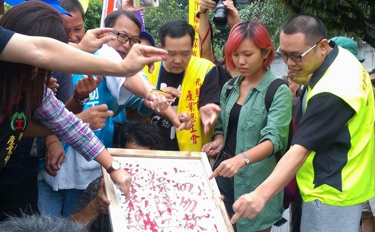 勞團28日下午刺破中指寫出「保障工人權益，切勿砍7天假」寫書，送進總統府陳情。  圖：翻攝臉書
