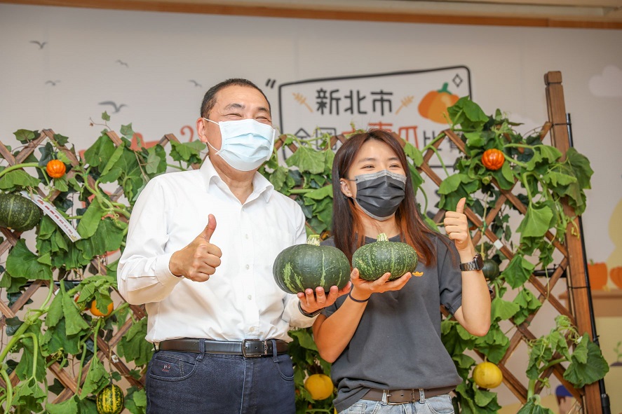 青農聯誼會長盧苡甄與侯友宜分享摘採及挑選南瓜的「眉角」（訣竅）。 圖：新北市農業局提供