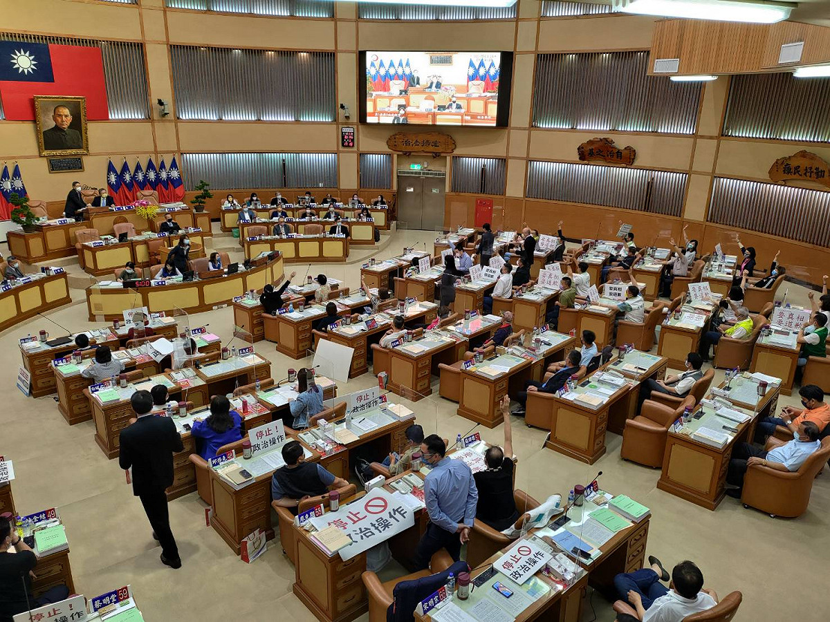 民進黨新北市議會黨團針對「恩恩」案，連兩天發動變更議程、要求成立專案調查小組，下午在議會表決，24席民進黨議員（右側）手舉得老高，仍都遭否決。 圖：王峻昌／攝