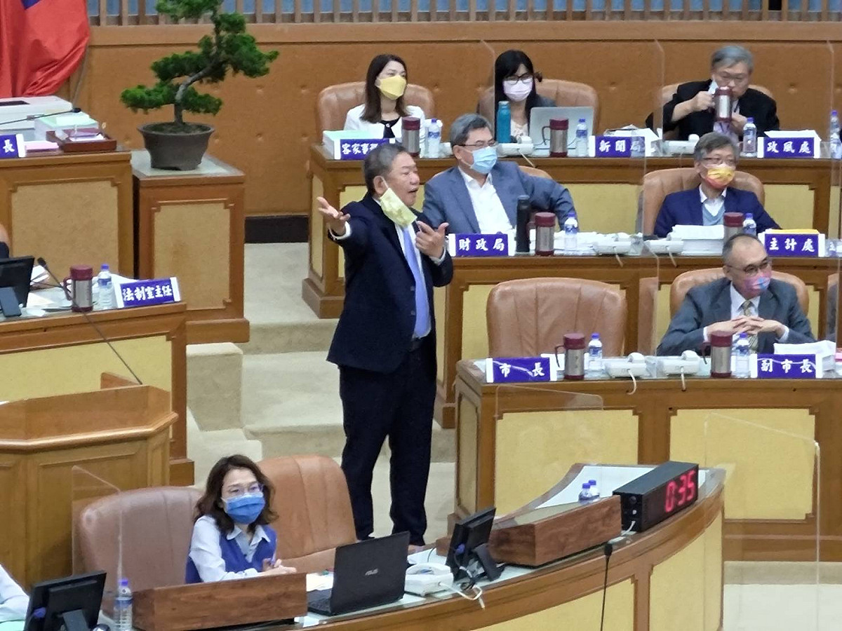 新北市議長蔣根煌下午主持會議，因藍綠口角，一度走下主席檯制止及化多雙方衝突。 圖：王峻昌／攝