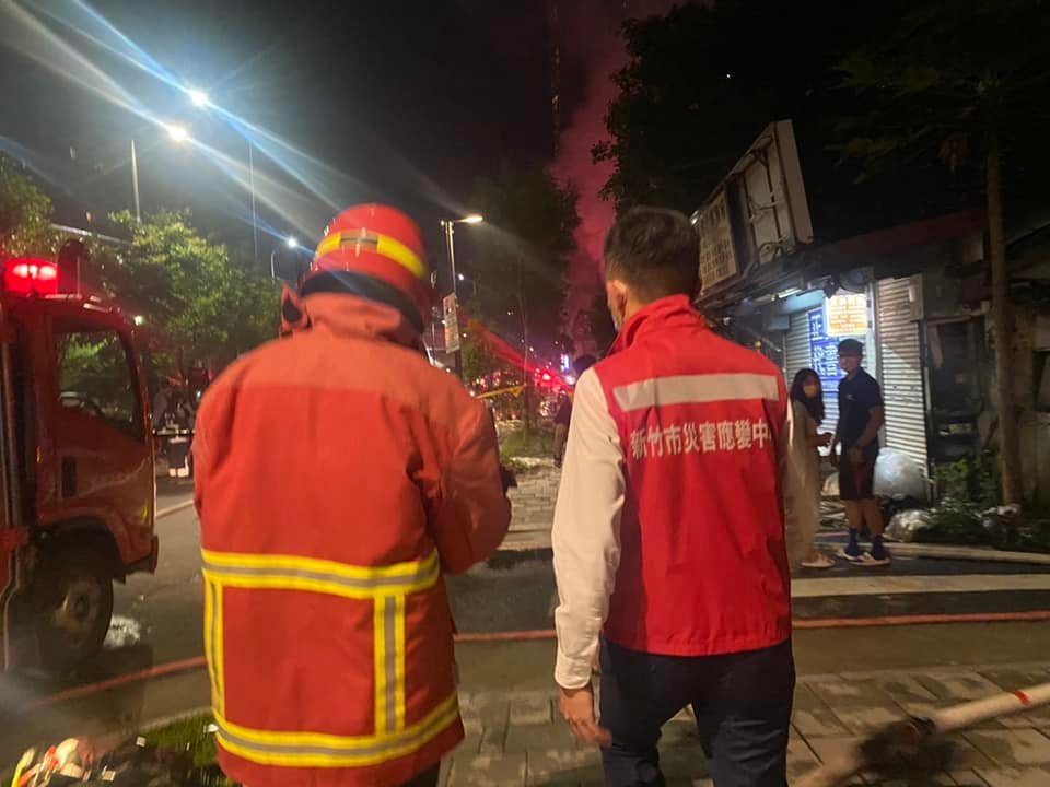 新竹市東大路與中央路口某間輪胎行15日夜間發生二級火警，竹市出動25輛救護車輛，並派遣逾160位警消人員支援，新竹市長林智堅（右）也趕赴現場了解。 圖：翻攝自林智堅臉書