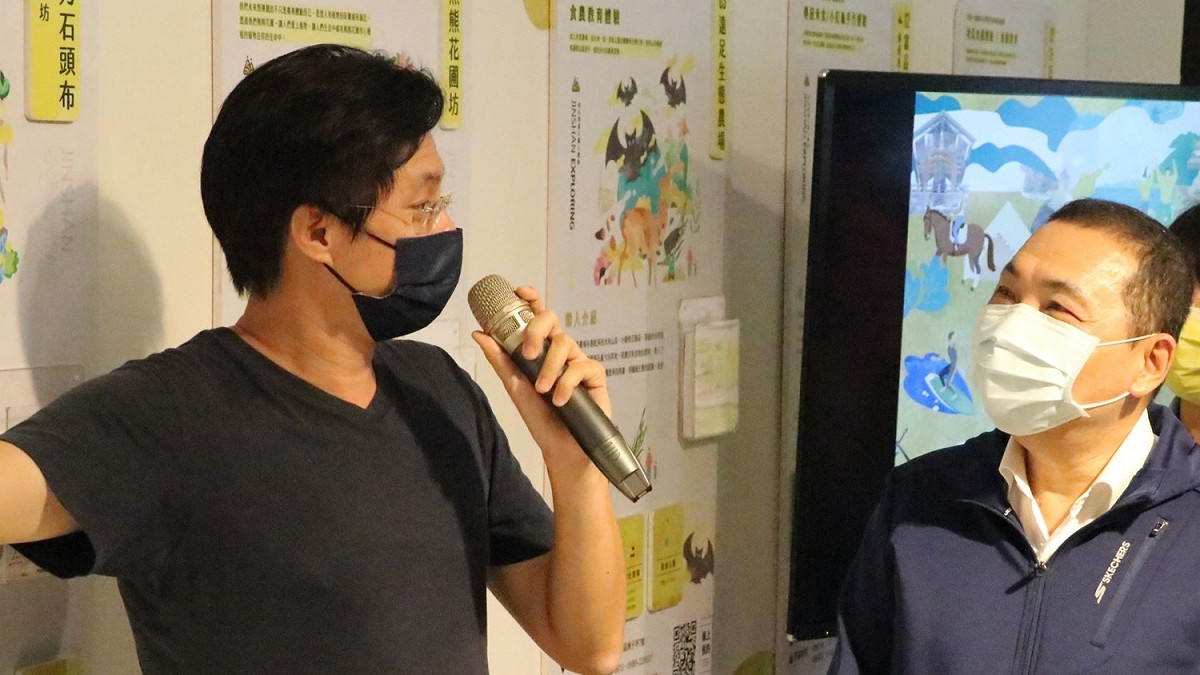 金山漫遊營運長賴家華（左）向新北市長侯友宜（右）介紹金山漫遊基地。