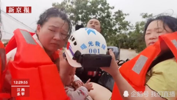 救援人員將頭盔讓給嬰兒使用。 圖：翻攝自新京報