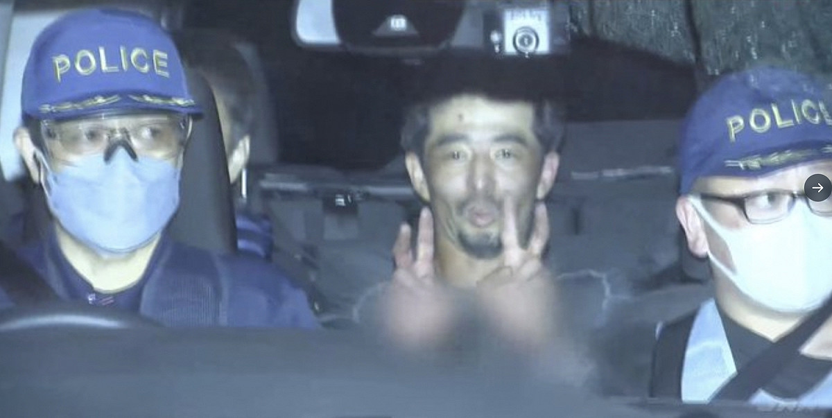 日本一名男子為「重返監獄」狹持網咖女性店員與警方對峙近5小時，他落網後面對鏡頭雙手比出「勝利」手勢。 圖：截自推特@kawai_kanyu