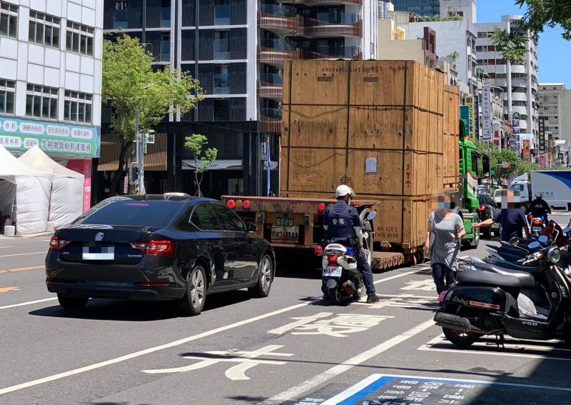 高雄街頭昨（23）日出現由員警護送的拖板車載運巨形木箱，讓網友十分好奇箱內裝的究竟是什麼？ 圖／翻攝自爆廢公社臉書
