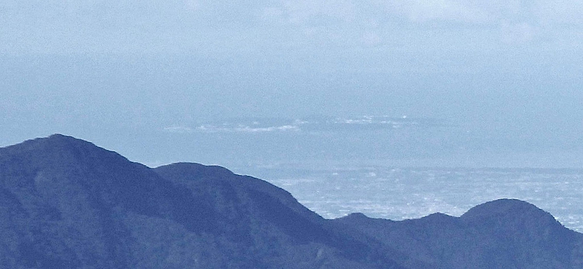 玉山氣象站人員李正紀拍攝從玉山看小琉球（遠方島嶼）的照片，引起熱議。 圖：翻攝自鄭明典臉書/李正紀攝