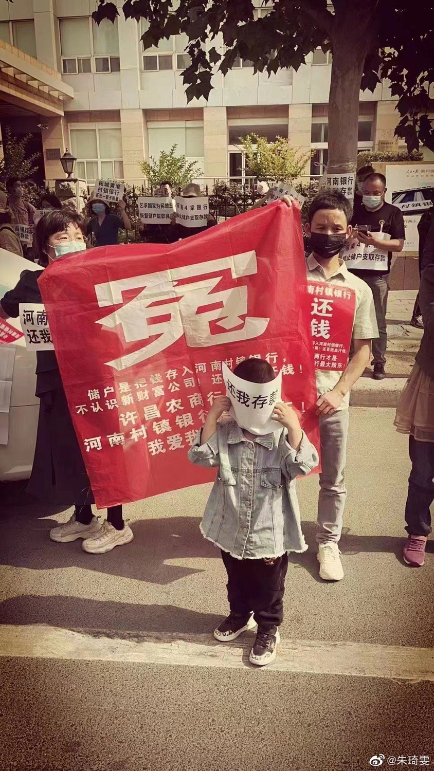 儲戶在銀保監局門口攜家帶眷維權，要求銀行吐出存款。 圖:翻攝自微博