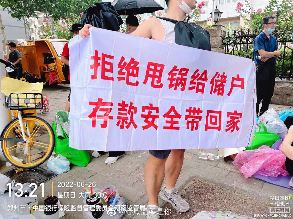 儲戶在銀行門口舉布條維權。 圖:翻攝自微博