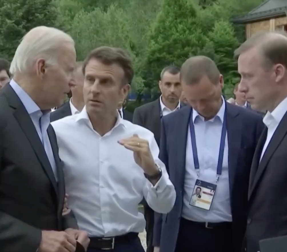 美國總統拜登（Joe Biden）正與法國總統馬克宏（Emmanuel Macron）討論能源問題，隨即被助理打斷。 圖：擷取自環球網