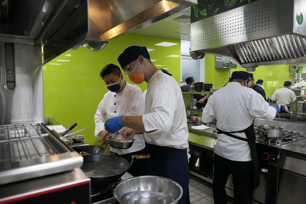 饗賓餐旅總經理陳毅航，到每組參賽夥伴的料理檯邊，瞭解料理過程並為他們加油打氣。 圖：醒吾科技大學提供