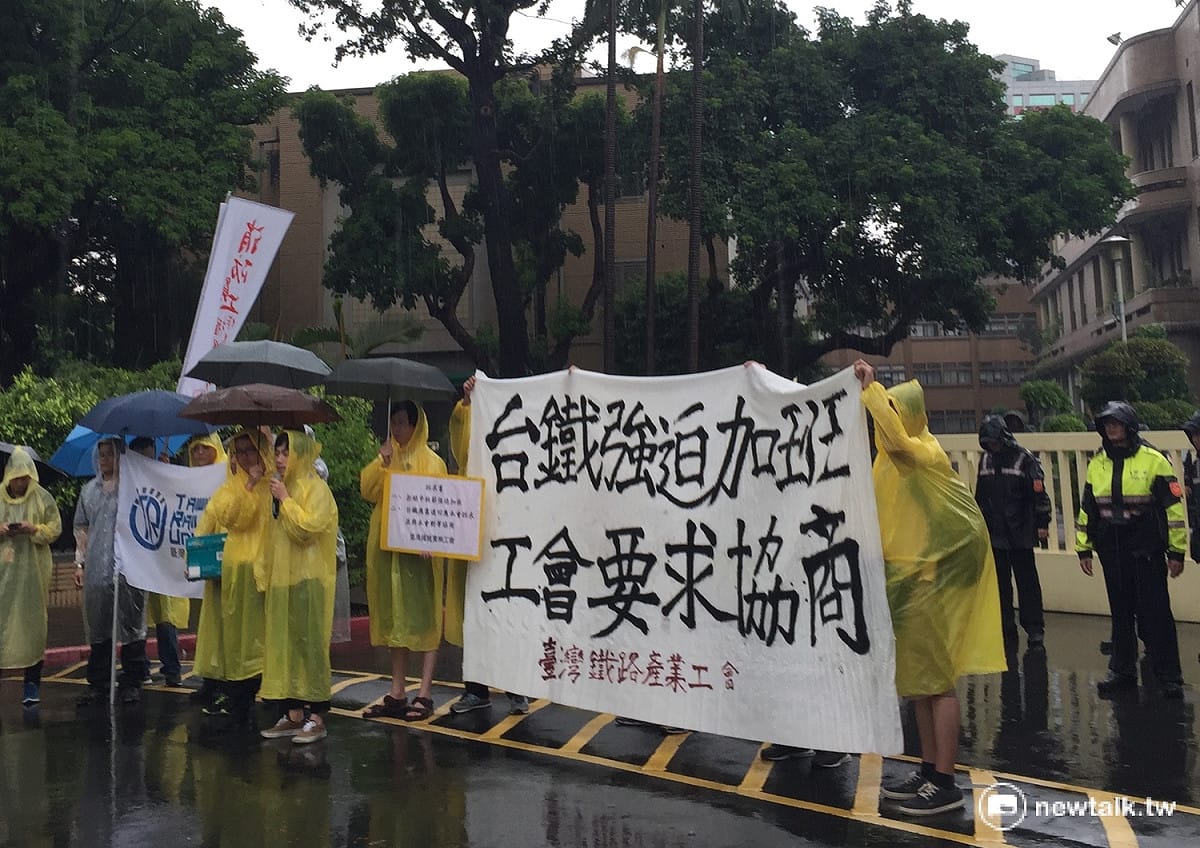 台鐵產業工會9日下午冒雨赴行政院大門，抗議台鐵強迫加班，並要求台鐵儘速回應訴求。 圖：柯昱安/攝