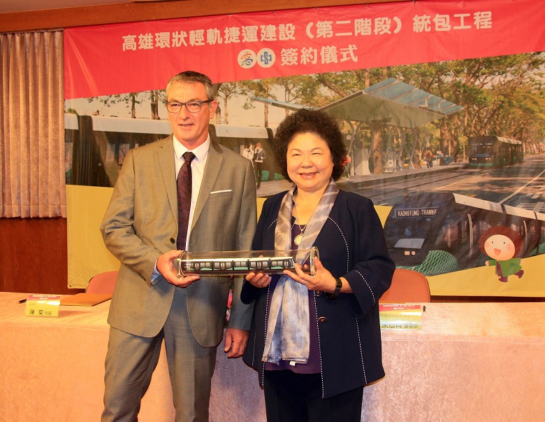 ALSTOM TRANSPORT 技術經理 Bruno Hamon致贈2階輕軌車輛模型給市長陳菊，象徵啟動高雄輕軌PLUS 活力。 圖：高雄市政府提供