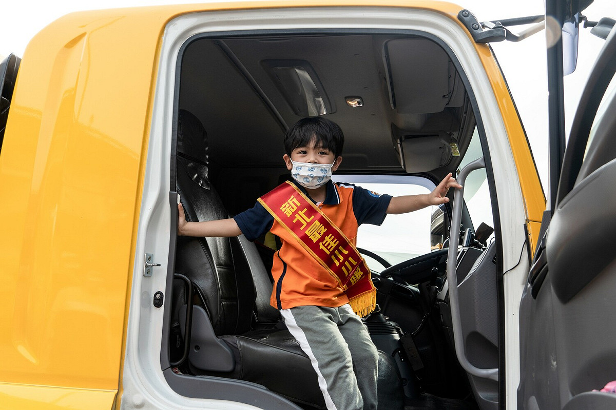 小小清潔隊員開心搭乘垃圾車。