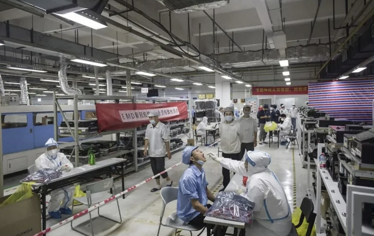 中國堅持清零政策，圖為富士康工廠工人排隊做核酸檢測。