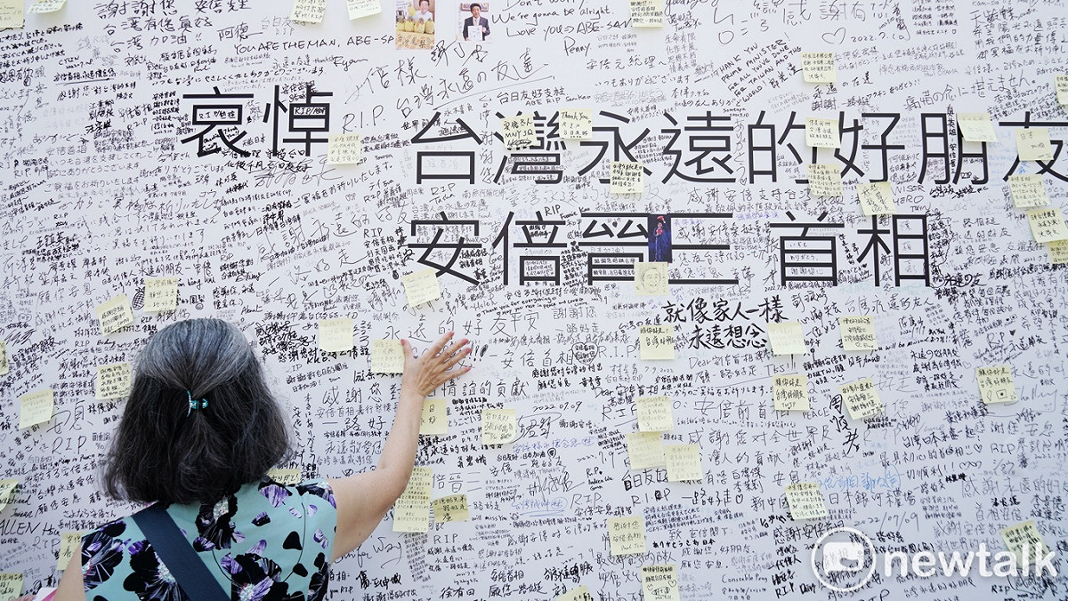 一位民眾將追悼日本前首相安倍晉三的文字貼在日本台灣交流協會台北事務所前。 圖：張良一/攝
