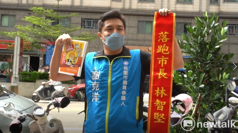 國民黨桃園市議員參選人謝克洋準備２份禮物要送給林智堅，祝賀林入籍桃園。 圖：林昀真／攝