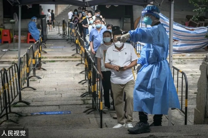 中國檢疫人員導引排隊民眾做PCR核酸檢測。